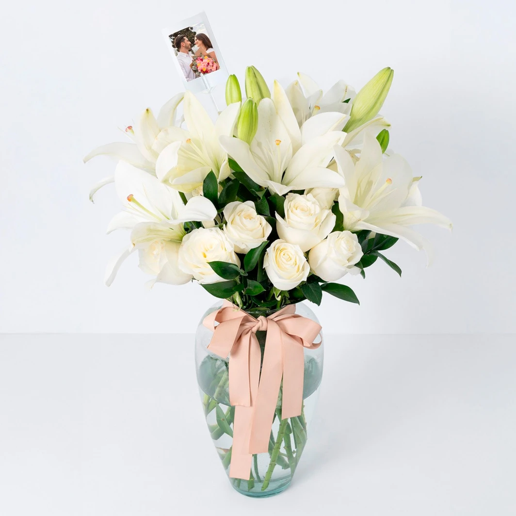 Arreglo de 12 rosas blancas y lilys en jarrón con mini foto 23637